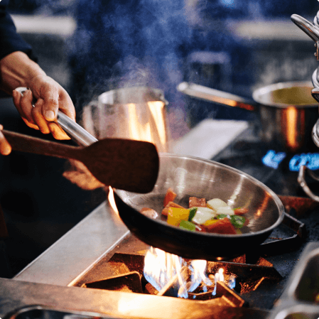 frying pan cooking vegetables over stovetop