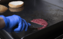 hamburger pattie cooking on stovetop